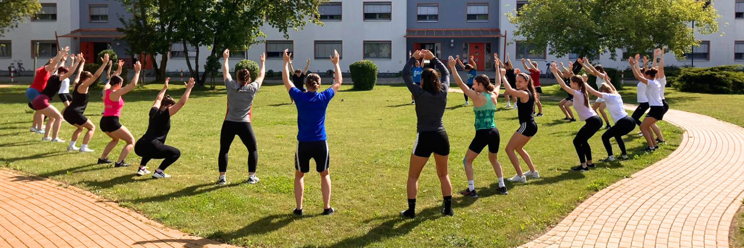 Eine Gruppe Menschen macht Fitnessuebungen im Freien.